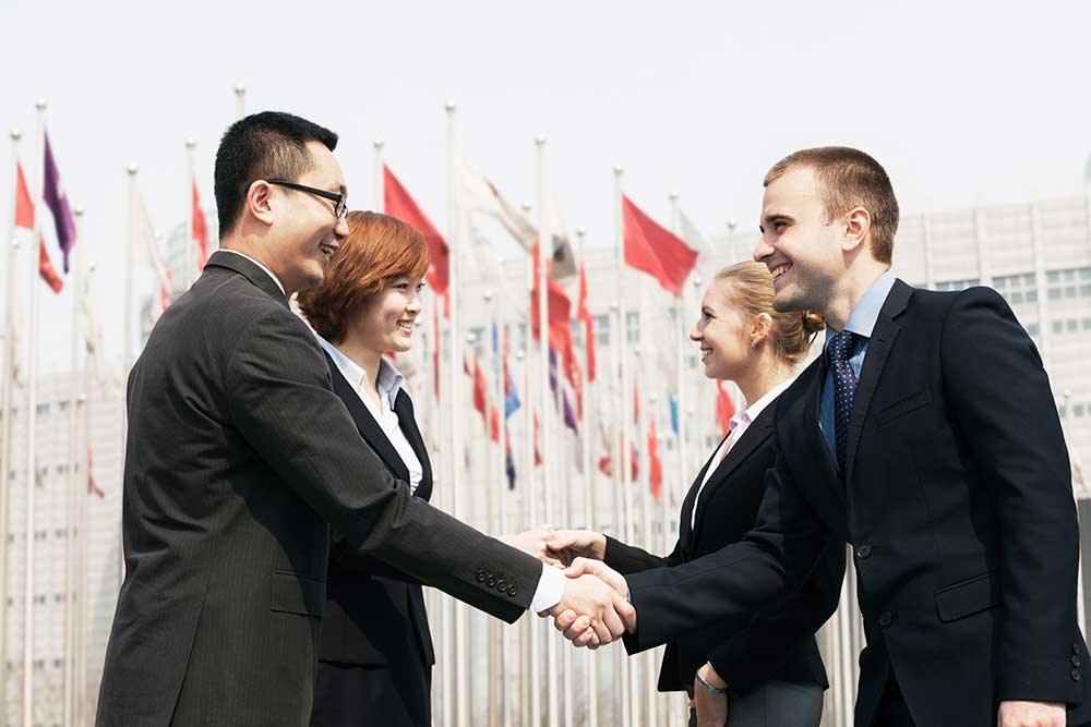 Shaking hands in front of WTO - Trade Facilitation Agreement