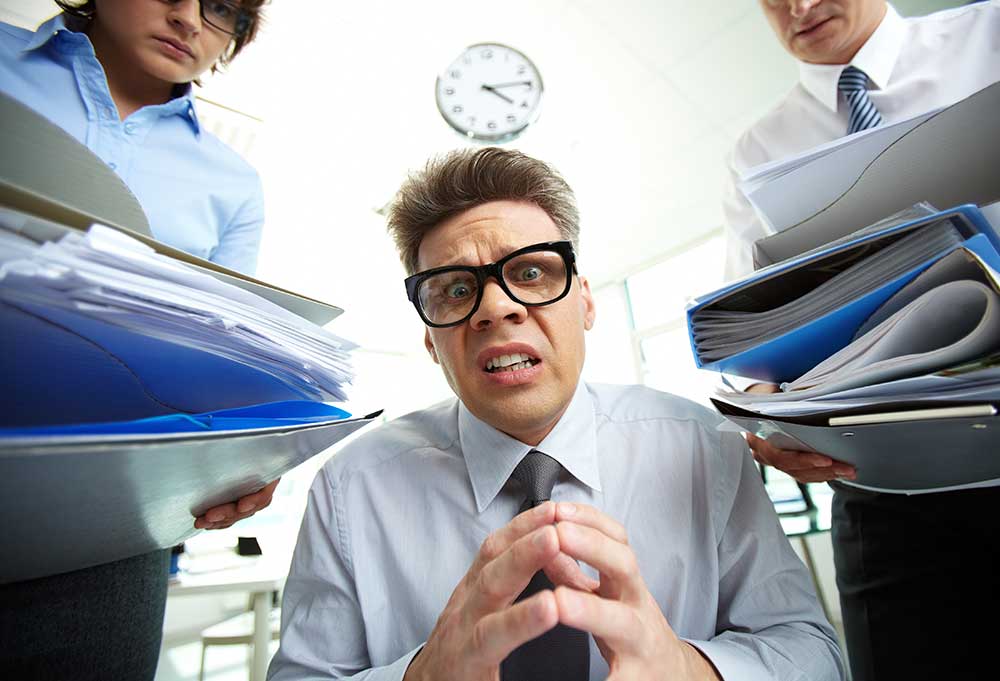 man with too much paperwork