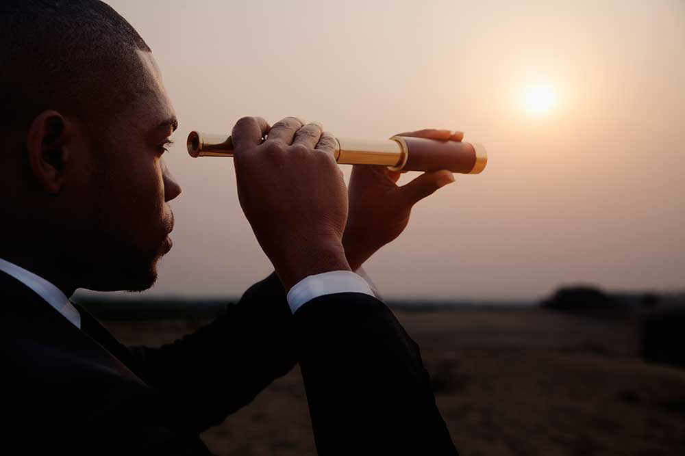 Business man looking through telescope