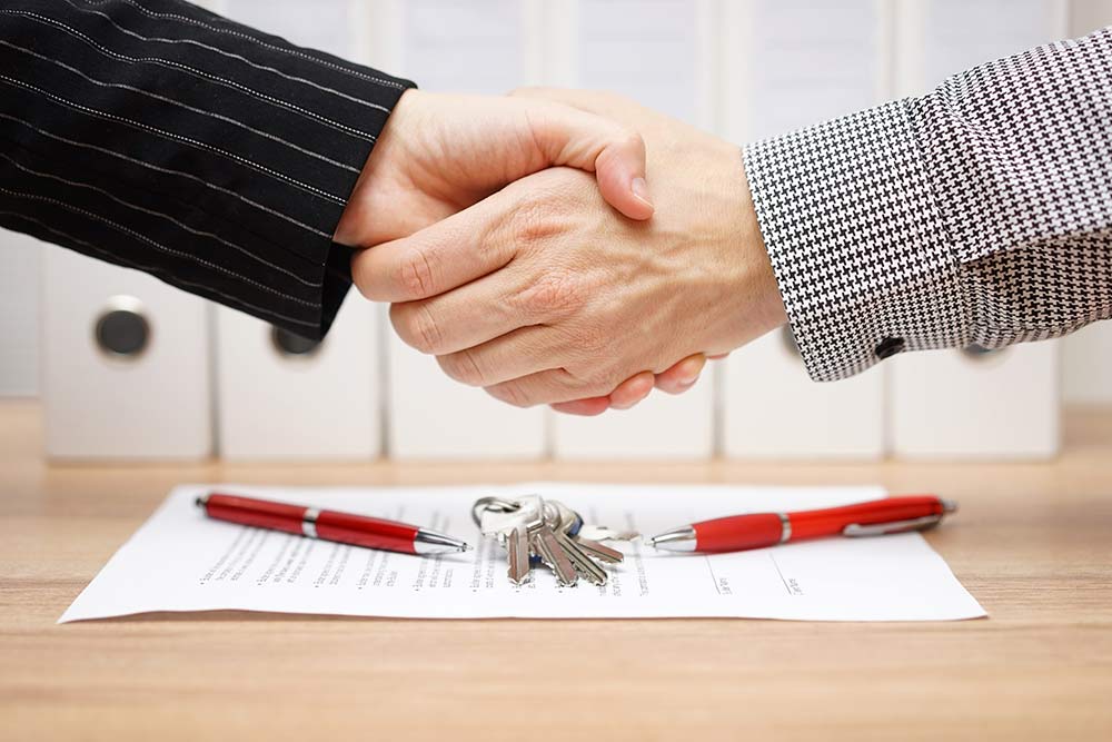 business handshake over signed contract