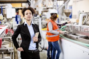 Female supervisor holds tablet in factory