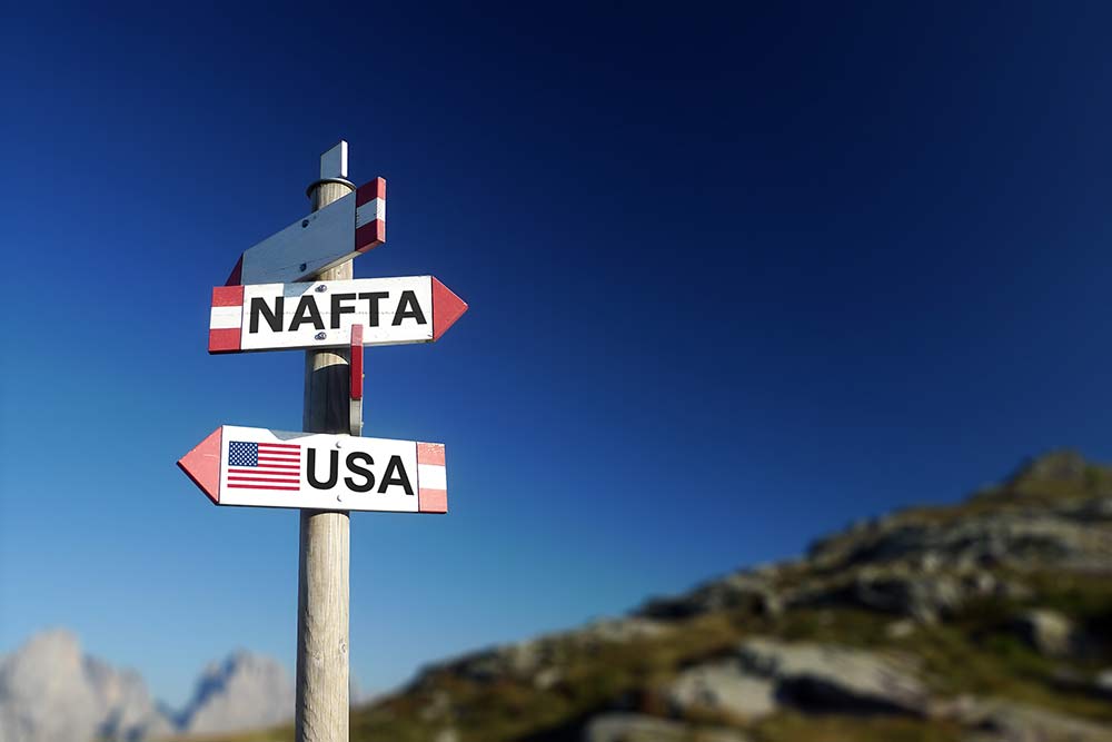 Signpost with directional signs featuring "NAFTA" "USA" "Canada" and "Mexico"