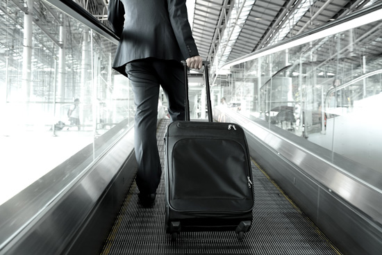 Business man with suitcase on escalator