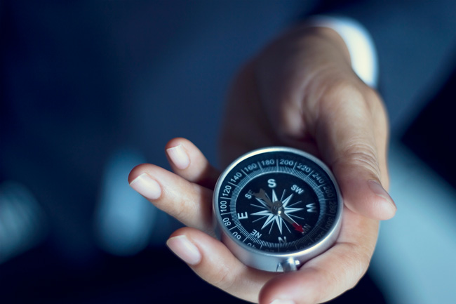 Business person holding a compass