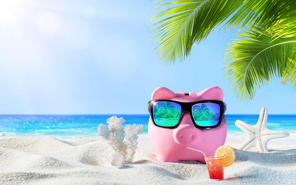 Piggy bank enjoying a holiday on a beach