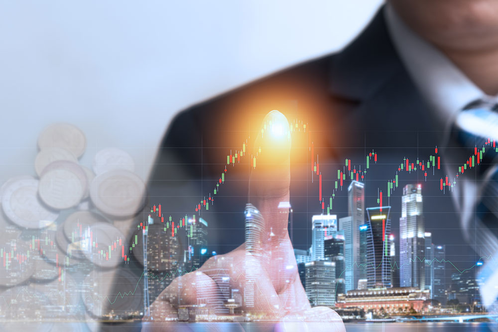 business man touching screen with stock graph and cityscape in the background