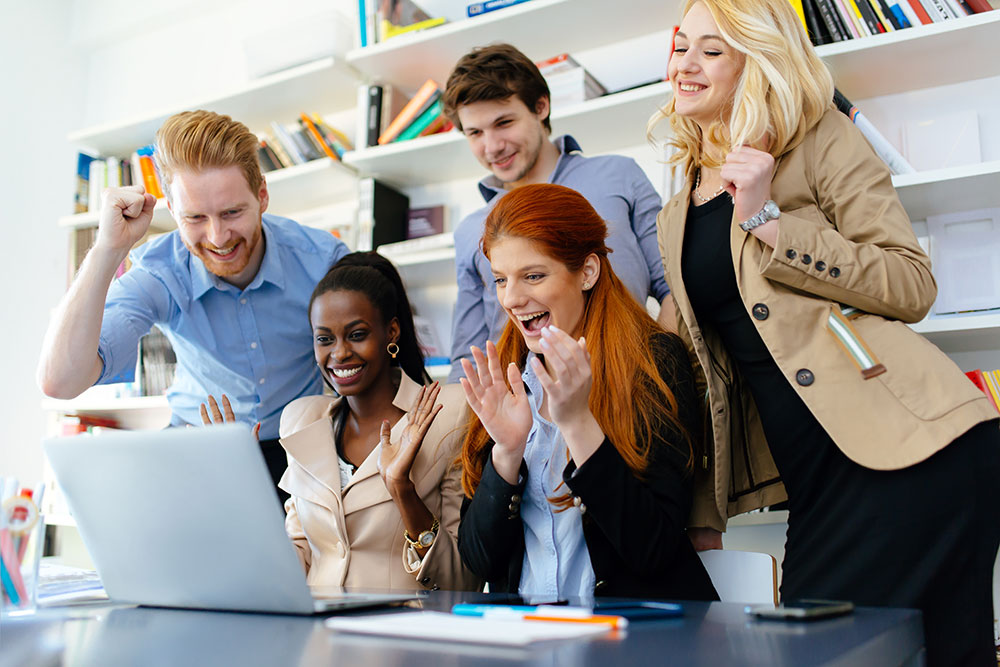 Happy colleagues looking at something exciting on a laptop