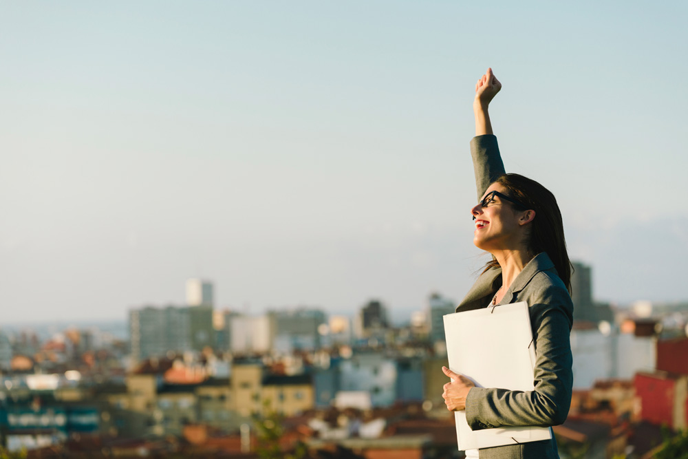 business woman with hand in the air celebrating