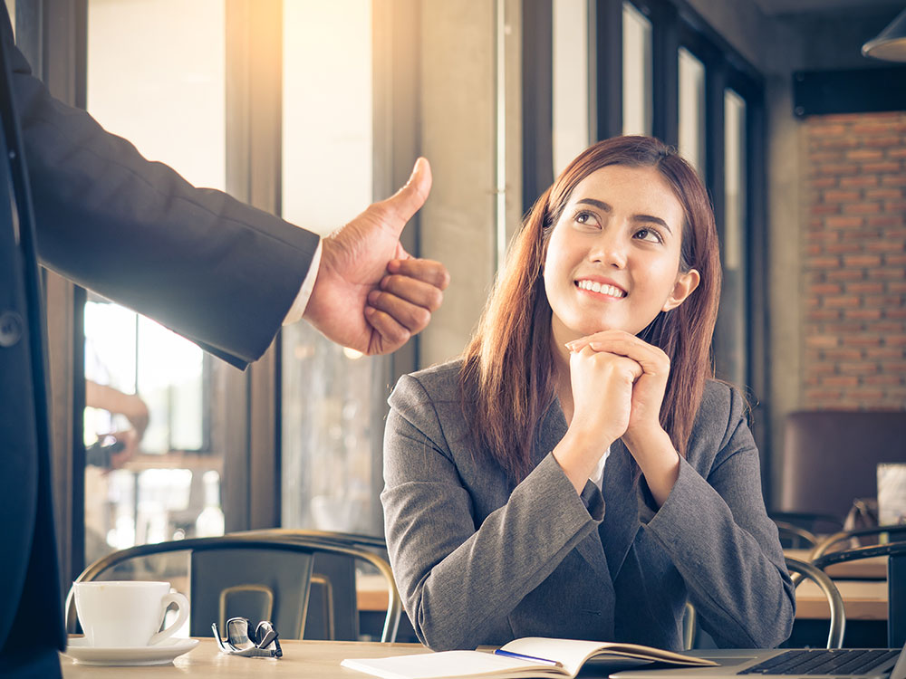 New female employee getting a thumbs up in approval