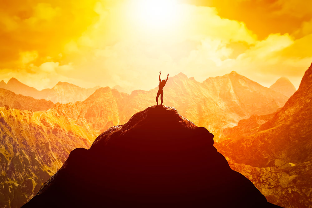 person standing on a mountain in golden sunlight