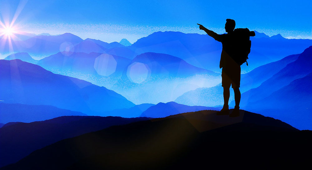 Silhouette of explorer looking out over mountains