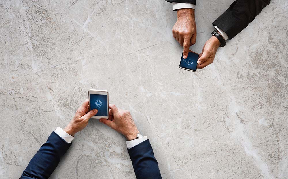 2 people holding mobile devices - international payments