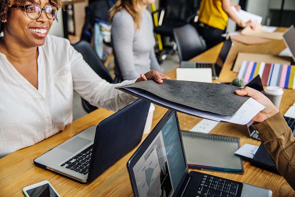 People exchanging a file at table