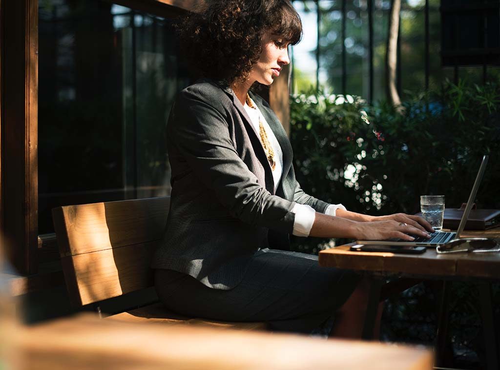 Business woman working on a laptop at an outdoor cafe