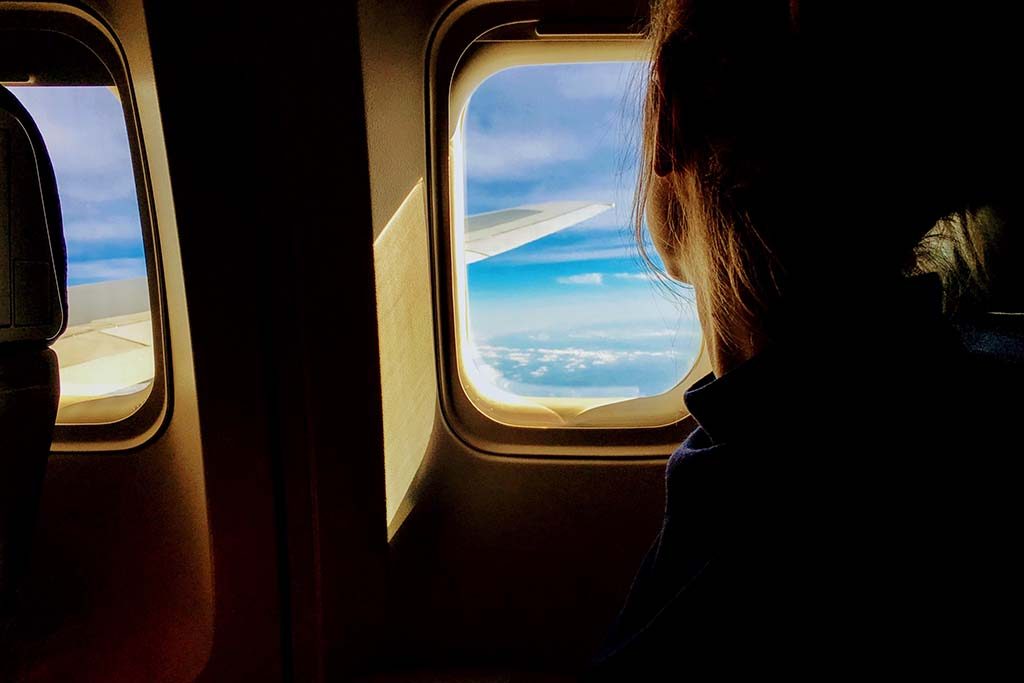 Woman in plane looking out window
