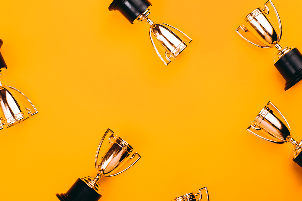 gold trophies on an orange background