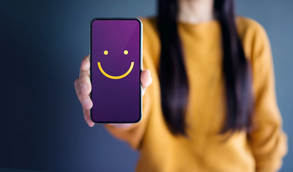 Happy customer holding a phone with a happy face