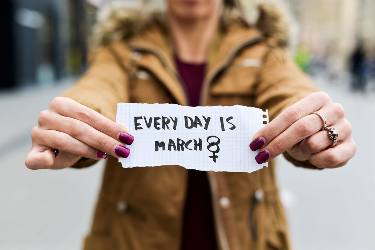 Woman holding paper that says "Every Day is March 8"