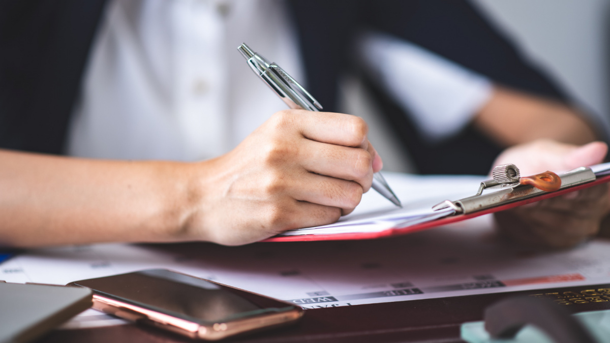 Woman writing on a note pad.