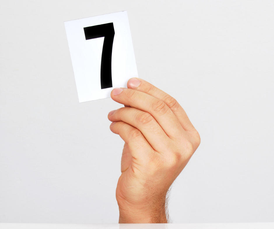 hand holding card with number 7 on it