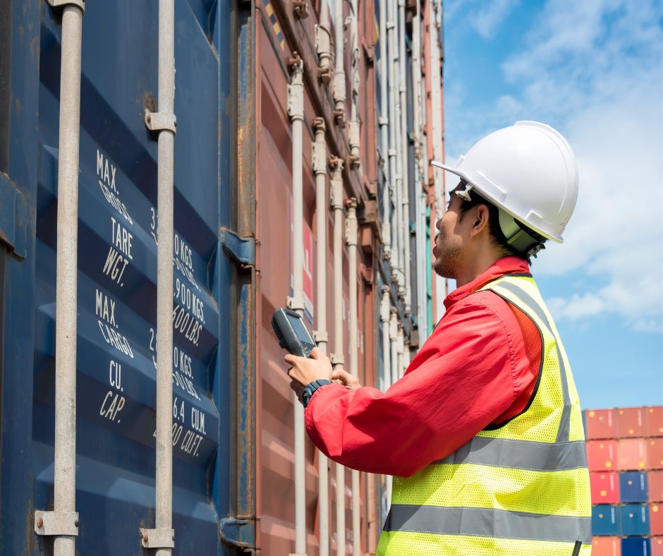 worker in hard hat inspecting shipping container