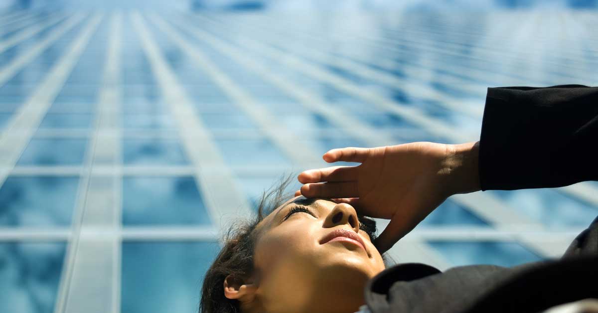 business woman in front of office building looking into the distance